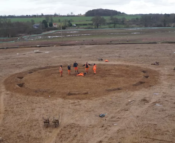 Team of archaeologists standing in the middle of the ring ditch.