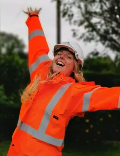 Happy archaeologist dressed in orange PPE. 