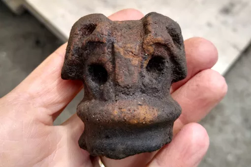 A close up of a hand holding a late Bronze Age axe mould fragment